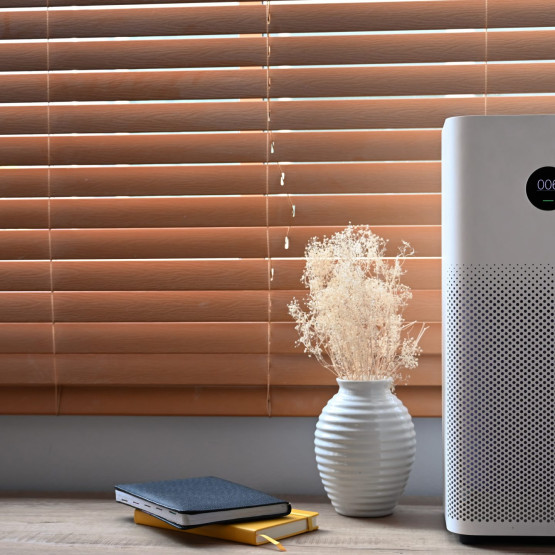 Air purifier in front of windows in living room for fresh air an