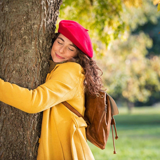 Young woman hugging tree in atumn at park